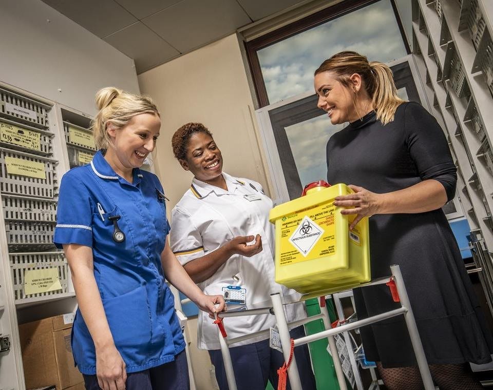 Hospital employees handling Bio System sharps container