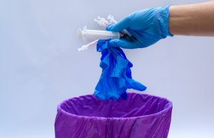 Medical waste, throw used gloves and syringes into the trash closeup