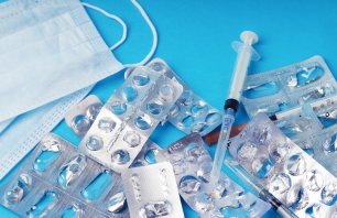 Used empty blister packs and medical waste on blue background. Concept of healthcare waste management, environmental pollution, safe recycling of plastic medicine packaging and eco pharmacology. Close up.