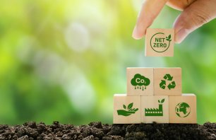 Net Zero and Carbon Neutral Concepts Net Zero Emissions Goals A climate-neutral long-term strategy Ready to put wooden blocks by hand with green net center icon and green icon on gray background.