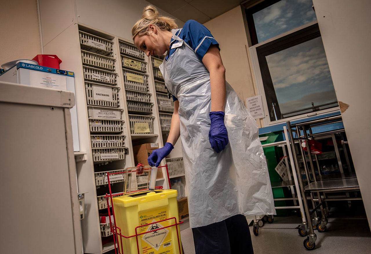 Hospital staff disposing of sharps waste into Bio System container